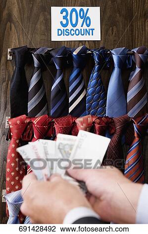 Businessman holding currency notes in a clothing store View Large Photo Image Stock Image - Businessman holding currency notes in a clothing store. Fotosearch