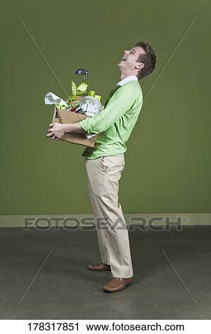 Businessman holding his belongings and smiling View Large Photo Image Stock Image - Businessman holding his belongings and smiling. Fotosearch