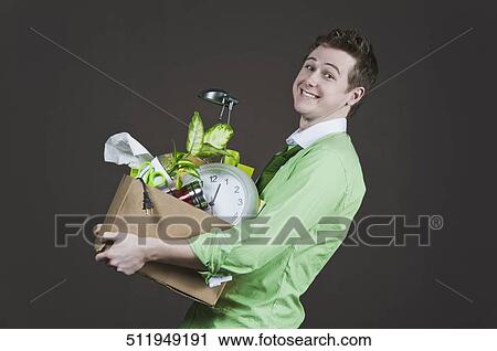 Businessman holding his belongings and smiling View Large Photo Image Stock Image - Businessman holding his belongings and smiling. Fotosearch