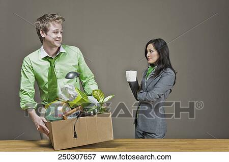Businessman holding his belongings and a businesswoman holding a cup of coffee View Large Photo Image Stock Photo - Businessman holding his belongings and a businesswoman holding a cup of coffee. Fotosearch