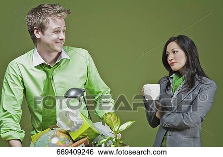 Businessman holding his belongings and a businesswoman holding a cup of coffee View Large Photo Image Stock Photograph - Businessman holding his belongings and a businesswoman holding a cup of coffee. Fotosearch