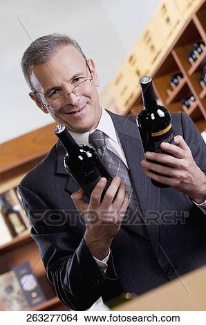 Businessman holding wine bottles View Large Photo Image Picture - Businessman holding wine bottles. Fotosearch