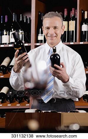 Businessman holding wine bottles View Large Photo Image Stock Photo - Businessman holding wine bottles. Fotosearch