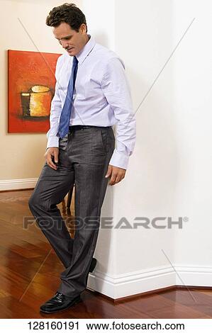 Businessman leaning against a wall in a house View Large Photo Image Stock Image - Businessman leaning against a wall in a house. Fotosearch