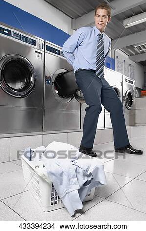 Picture - Businessman putting a briefcase into a washing machine. Fotosearch