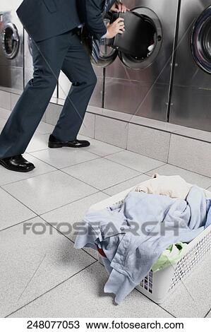 Businessman putting a briefcase into a washing machine View Large Photo Image Stock Image - Businessman putting a briefcase into a washing machine. Fotosearch