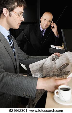 Businessman reading a financial newspaper View Large Photo Image Stock Image - Businessman reading a financial newspaper. Fotosearch