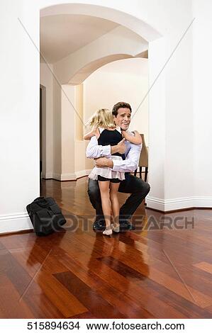 Picture - Businessman receiving a warm welcome from his daughter. Fotosearch