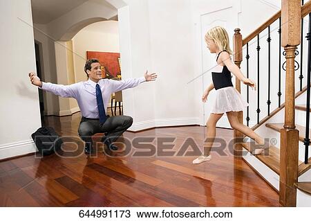Businessman receiving a warm welcome from his daughter View Large Photo Image Stock Image - Businessman receiving a warm welcome from his daughter. Fotosearch