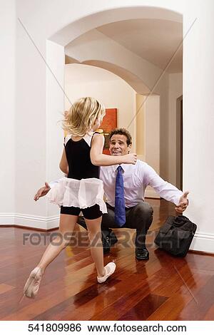 Businessman receiving a warm welcome from his daughter View Large Photo Image Stock Photograph - Businessman receiving a warm welcome from his daughter. Fotosearch