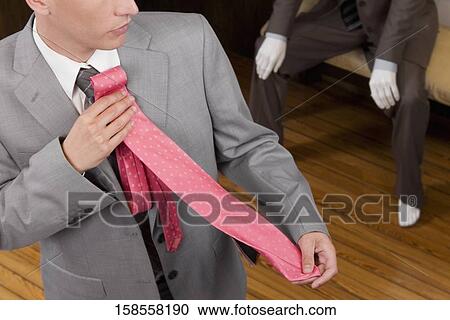 Businessman selecting a tie in a clothing store View Large Photo Image Stock Image - Businessman selecting a tie in a clothing store. Fotosearch