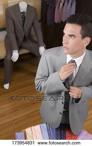 Businessman selecting a tie in a clothing store View Large Photo Image Stock Image - Businessman selecting a tie in a clothing store. Fotosearch