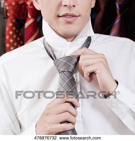 Businessman selecting a tie in a clothing store View Large Photo Image Stock Image - Businessman selecting a tie in a clothing store. Fotosearch