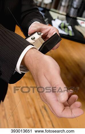 Businessman selecting cuff links in a clothing store View Large Photo Image Stock Image - Businessman selecting cuff links in a clothing store. Fotosearch