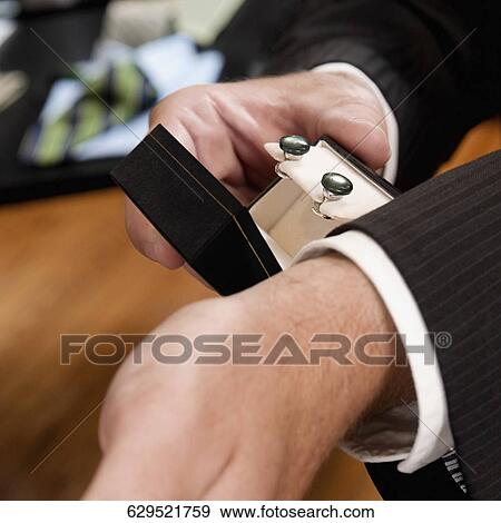 Businessman selecting cuff links in a clothing store View Large Photo Image Stock Photo - Businessman selecting cuff links in a clothing store. Fotosearch