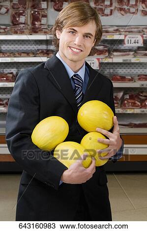 Businessman shopping canary melons in a supermarket View Large Photo Image Stock Image - Businessman shopping canary melons in a supermarket. Fotosearch