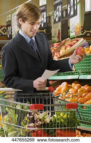 Businessman shopping in a supermarket View Large Photo Image Stock Photo - Businessman shopping in a supermarket. Fotosearch