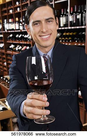 Businessman showing a wine glass in a bar View Large Photo Image Stock Photograph - Businessman showing a wine glass in a bar. Fotosearch