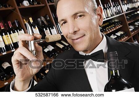 Businessman smelling cork of a wine bottle View Large Photo Image Stock Photograph - Businessman smelling cork of a wine bottle. Fotosearch