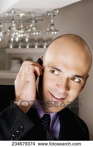 Businessman talking on a mobile phone in a bar View Large Photo Image Picture - Businessman talking on a mobile phone in a bar. Fotosearch