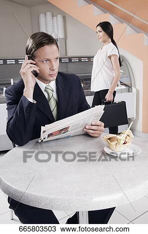 Businessman talking on a mobile phone in an ice cream parlor View Large Photo Image Stock Image - Businessman talking on a mobile phone in an ice cream parlor. Fotosearch