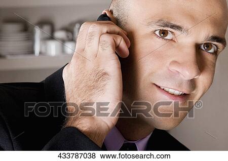 Businessman talking on a mobile phone in a bar View Large Photo Image Stock Photo - Businessman talking on a mobile phone in a bar. Fotosearch