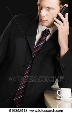 Businessman talking on a mobile phone View Large Photo Image Stock Photo - Businessman talking on a mobile phone. Fotosearch