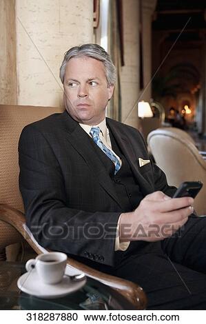 Businessman text messaging on a mobile phone, Biltmore Hotel, Coral Gables, Florida, USA View Large Photo Image Stock Image - Businessman text messaging on a mobile phone, Biltmore Hotel, Coral Gables, Florida, USA. Fotosearch