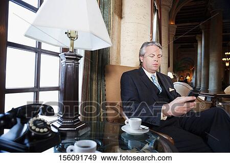 Businessman text messaging on a mobile phone, Biltmore Hotel, Coral Gables, Florida, USA View Large Photo Image Stock Photo - Businessman text messaging on a mobile phone, Biltmore Hotel, Coral Gables, Florida, USA. Fotosearch