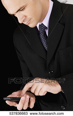 Businessman using a mobile phone in a bar View Large Photo Image Stock Image - Businessman using a mobile phone in a bar. Fotosearch