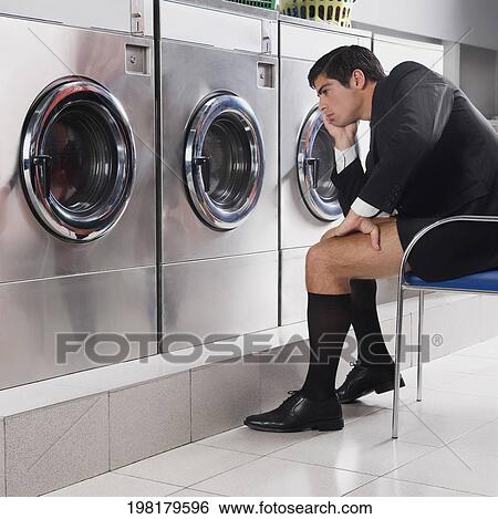 Businessman waiting in a laundromat View Large Photo Image Stock Photograph - Businessman waiting in a laundromat. Fotosearch