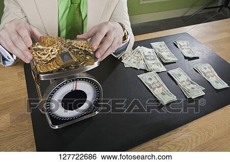 Stock Photograph - Businessman weighing gold jewelry. Fotosearch