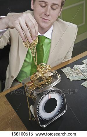 Stock Photography - Businessman weighing gold jewelry. Fotosearch