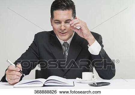 Stock Photograph - Businessman writing in a diary. Fotosearch