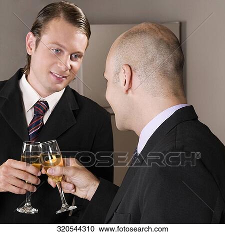 Businessmen toasting with wine in a bar View Large Photo Image Stock Image - Businessmen toasting with wine in a bar. Fotosearch