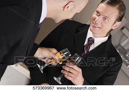 Businessmen toasting with wine in a bar View Large Photo Image Stock Photo - Businessmen toasting with wine in a bar. Fotosearch