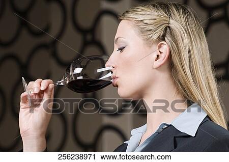 Stock Image - Businesswoman drinking wine. Fotosearch
