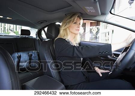 Stock Image - Businesswoman driving a car, Biltmore Hotel, Coral Gables, Florida, USA. Fotosearch