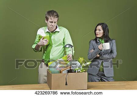 Businesswoman holding a cup of coffee and standing near a fired businessman View Large Photo Image Stock Photograph - Businesswoman holding a cup of coffee and standing near a fired businessman. Fotosearch