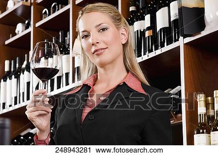 Businesswoman holding a glass of wine View Large Photo Image Stock Image - Businesswoman holding a glass of wine. Fotosearch