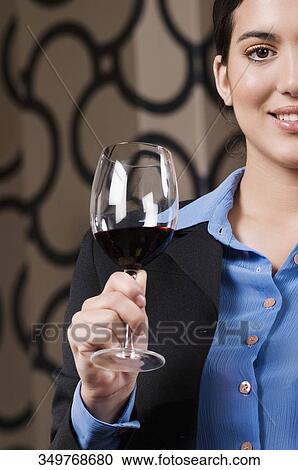 Businesswoman holding a glass of wine View Large Photo Image Stock Image - Businesswoman holding a glass of wine. Fotosearch