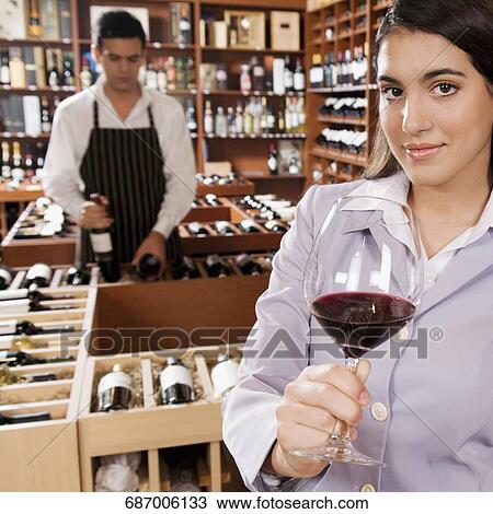 Businesswoman holding a glass of wine in a bar View Large Photo Image Stock Image - Businesswoman holding a glass of wine in a bar. Fotosearch