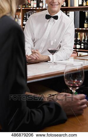 Businesswoman holding a glass of wine in a bar View Large Photo Image Stock Photograph - Businesswoman holding a glass of wine in a bar. Fotosearch