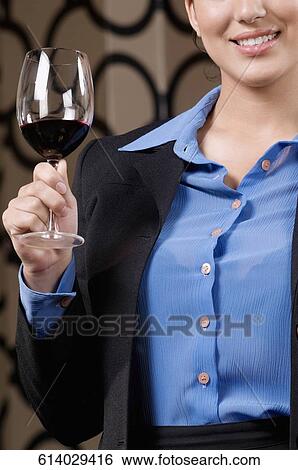 Stock Photograph - Businesswoman holding a glass of wine. Fotosearch