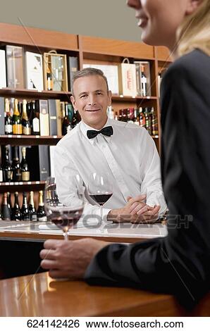 Stock Photograph - Businesswoman holding a glass of wine in a bar. Fotosearch