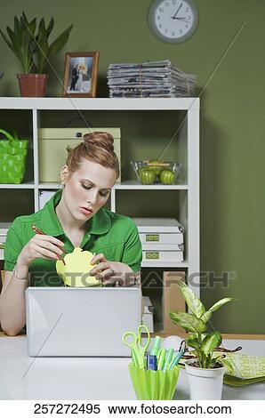 Stock Photography - Businesswoman in the office opening packaged food. Fotosearch