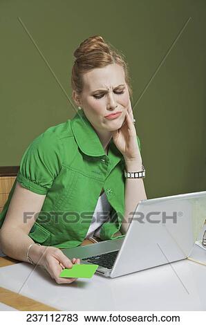 Businesswoman looking at a laptop in the office View Large Photo Image Stock Image - Businesswoman looking at a laptop in the office. Fotosearch