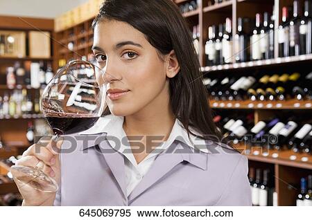Businesswoman smelling a glass of red wine View Large Photo Image Stock Photography - Businesswoman smelling a glass of red wine. Fotosearch