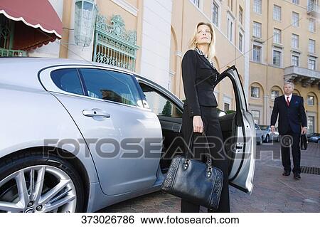 Stock Photograph - Businesswoman standing out of a car, Biltmore Hotel, Coral Gables, Florida, USA. Fotosearch