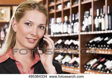 Businesswoman talking on a mobile phone in a bar View Large Photo Image Picture - Businesswoman talking on a mobile phone in a bar. Fotosearch
